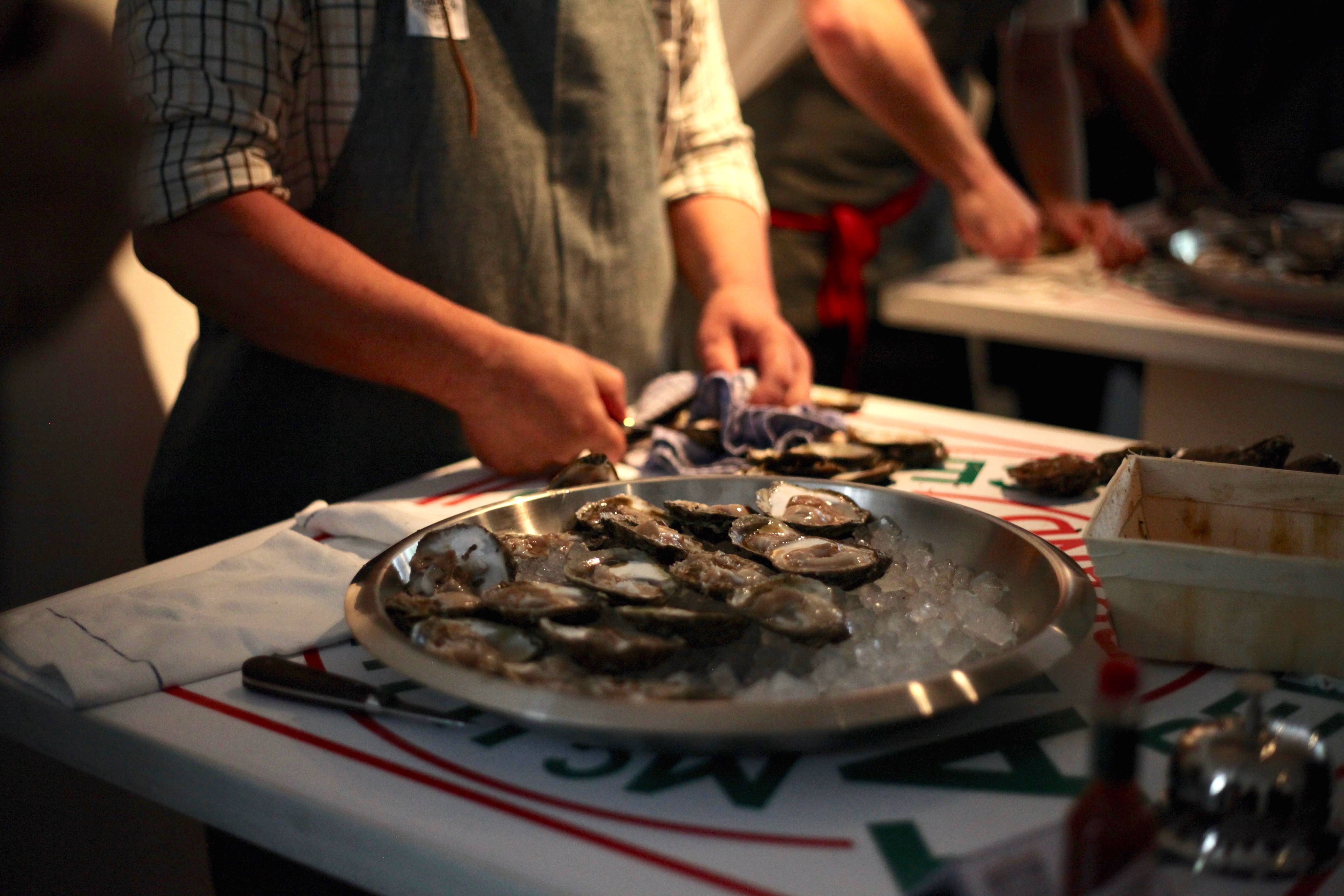 Antonio at his shucking station, halfway through shucking his 30 oysters and displaying them in a platter of ice
