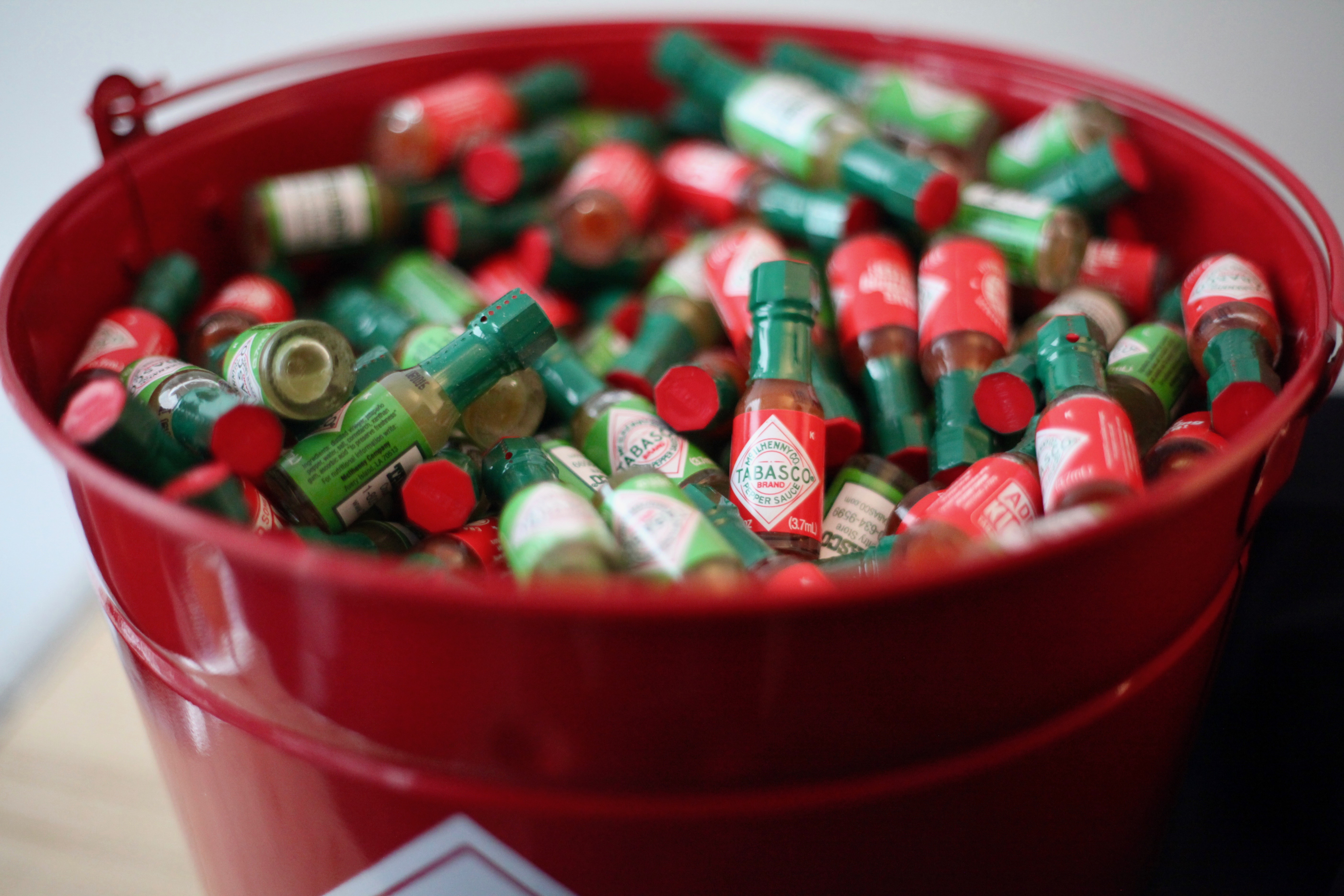 A bucket filled with tiny bottles of Tabasco